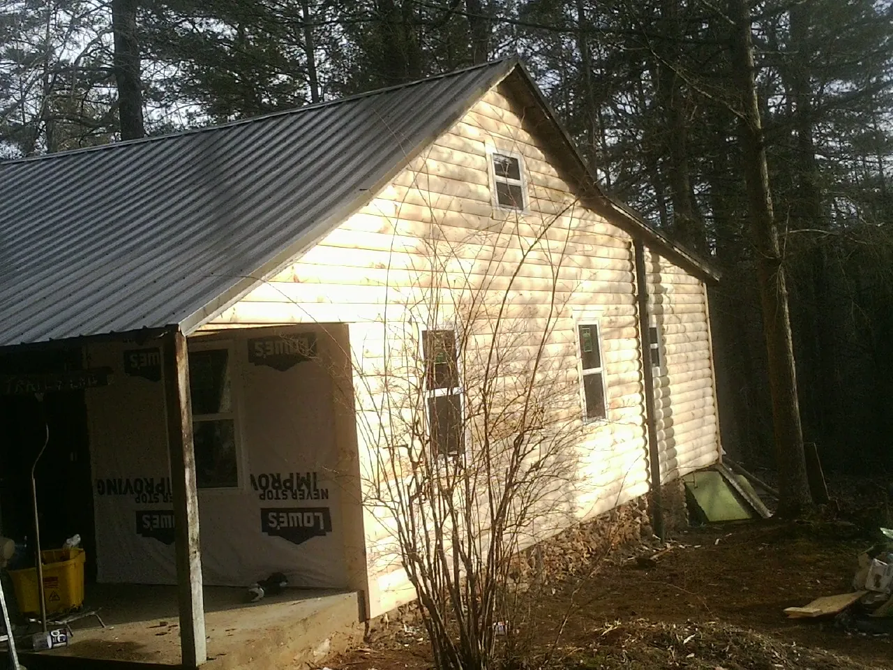 Log siding gable end under a dark metal roof edge in Columbus